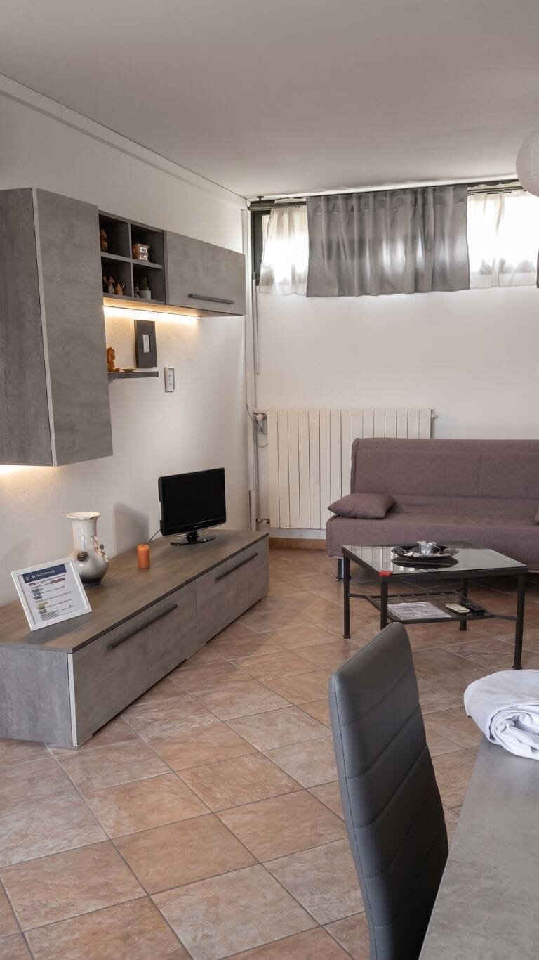 Vista del salone in profondità con mobile TV e pavimento terracotta