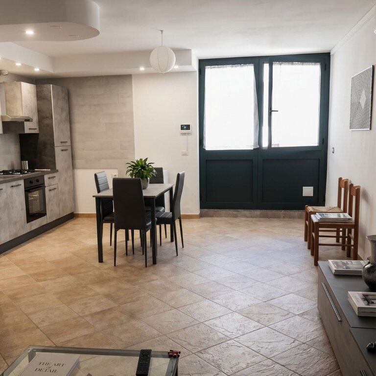 Soggiorno openspace con tavolo da pranzo, cucina e ingresso indipendente